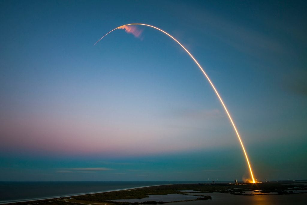 Data Pulse Tech rocket launch trajectory arc of SpaceX, representing cutting-edge aerospace and defense technology solutions